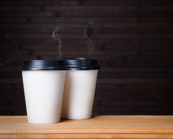 two steaming white coffee cups on a wooden table perfect for a cozy 7 coffee break