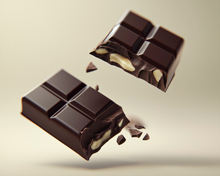 broken dark chocolate bar with three almond pieces flying through the air